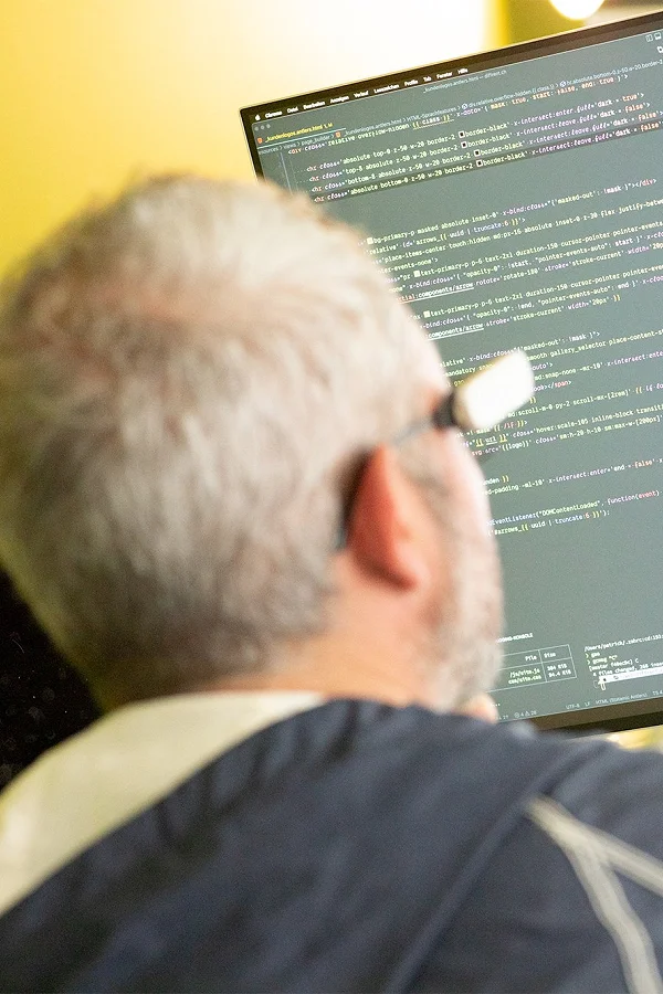Patrick programmiert am Bildschirm mit geöffnetem Code-Editor